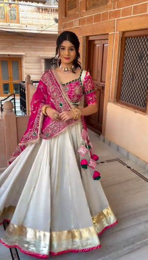 Off-white and rani pink roman silk Navratri chaniya choli with heavy embroidery
