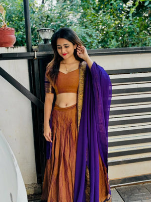 Earthy rust brown South Indian half saree lehenga with royal purple contrast