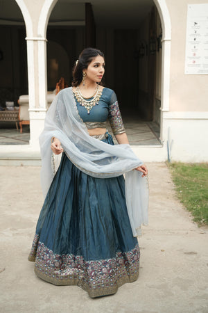 Teal Blue Shimmer Lehenga Choli featuring a highly detailed gold-silver zari weaving border paired with a contrasting ice blue scalloped dupatta by The Beauty Queen