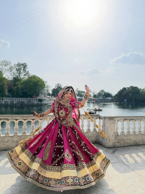 Model Twirling Outdoors In Rani Pink & Maroon Heavy Muslin Cotton With Canvas Patta With Lampi Lace Border & Real Mirror Work Navratri Lehenga Choli Set By The Beauty Queen