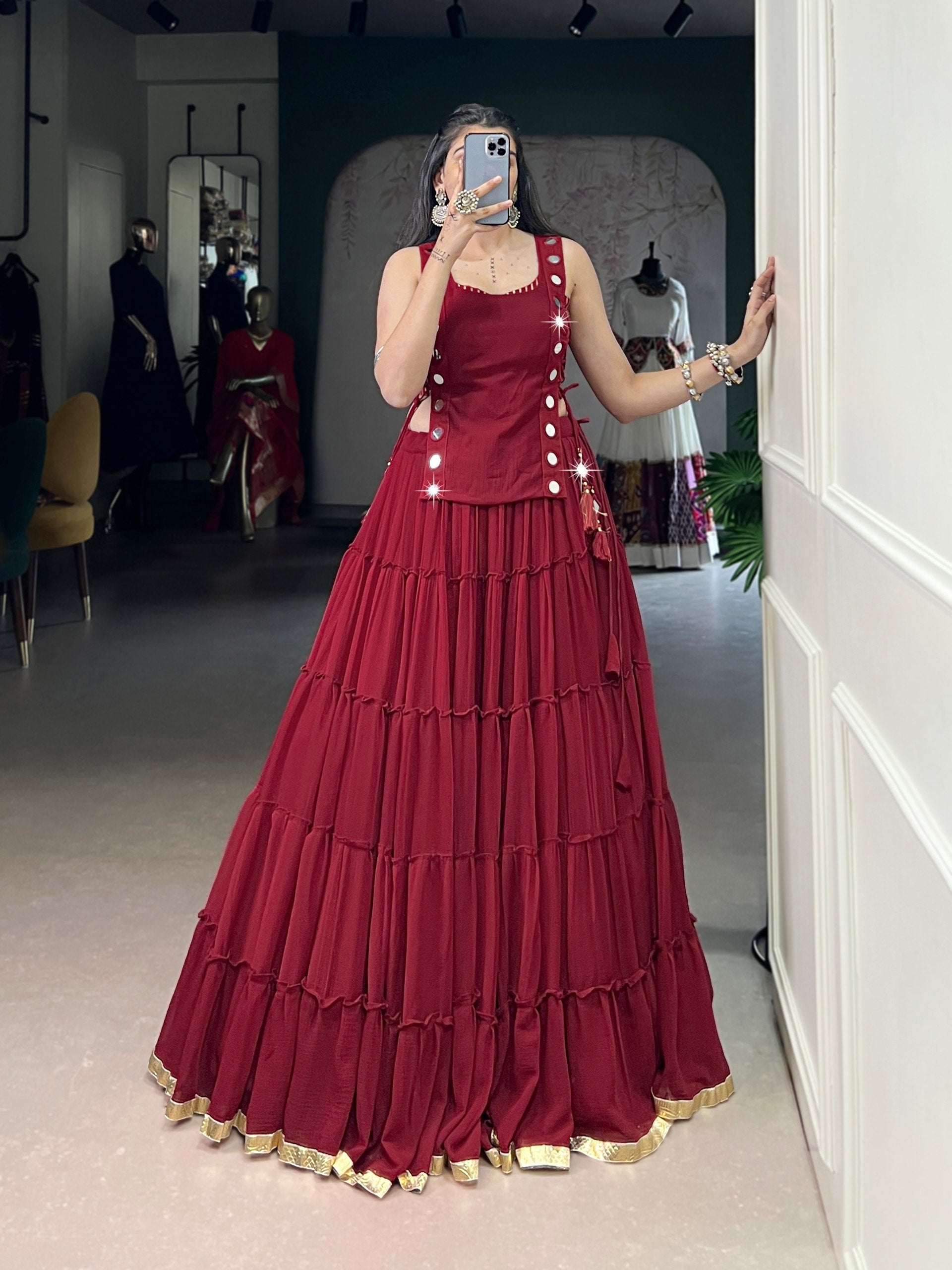 Deep red designer chaniya choli with mirror detailing and gold border
