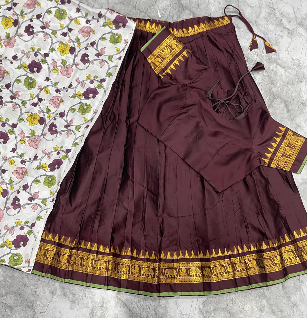 Brown South Indian half saree with temple patta border and off-white floral dupatta
