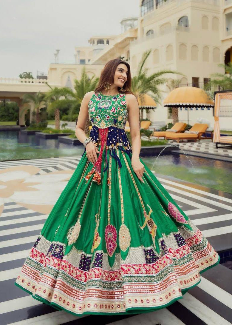 Emerald green heavy muslin cotton Navratri lehenga choli featuring Kutchi digital prints, real mirror work embellishments, and an embroidered navy blue blouse
