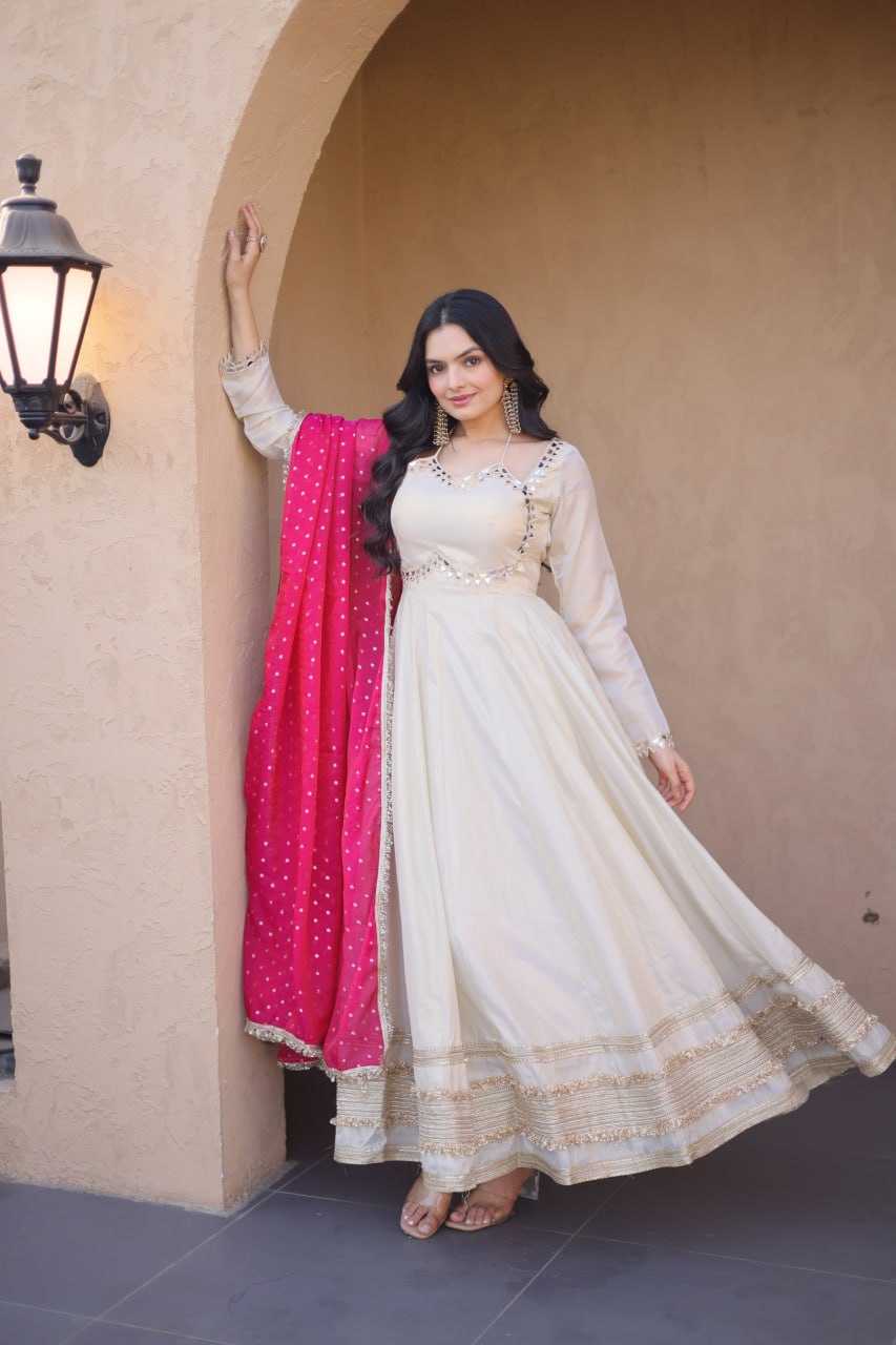 Off-White Cosmos Silk Anarkali Suit with real mirror work and Rani Pink dupatta by The Beauty Queen Surat.