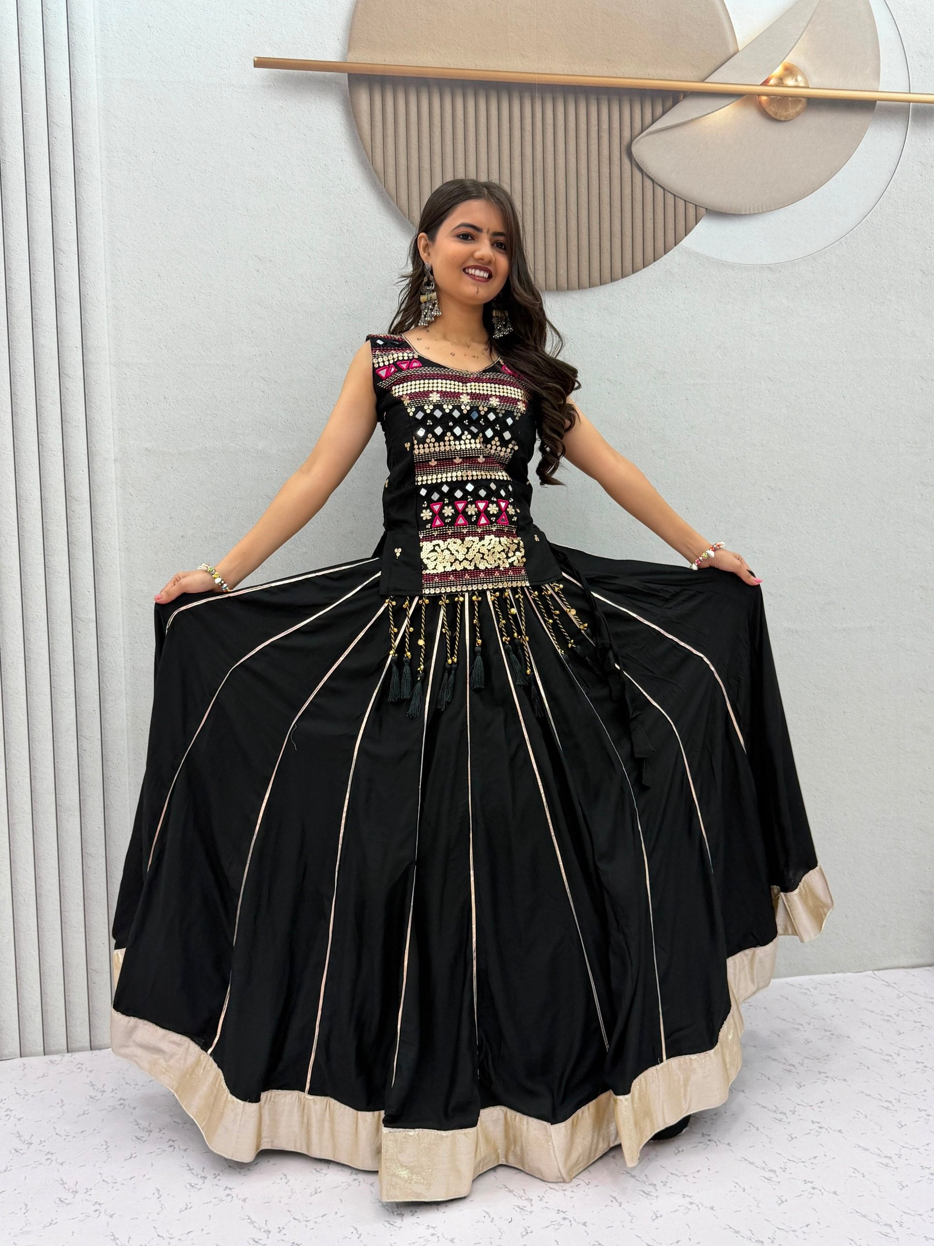 Model Posing Indoors Wearing Black Pure Cotton Mirror Hand Work & Ribbon Work Navratri Lehenga Choli Set By The Beauty Queen