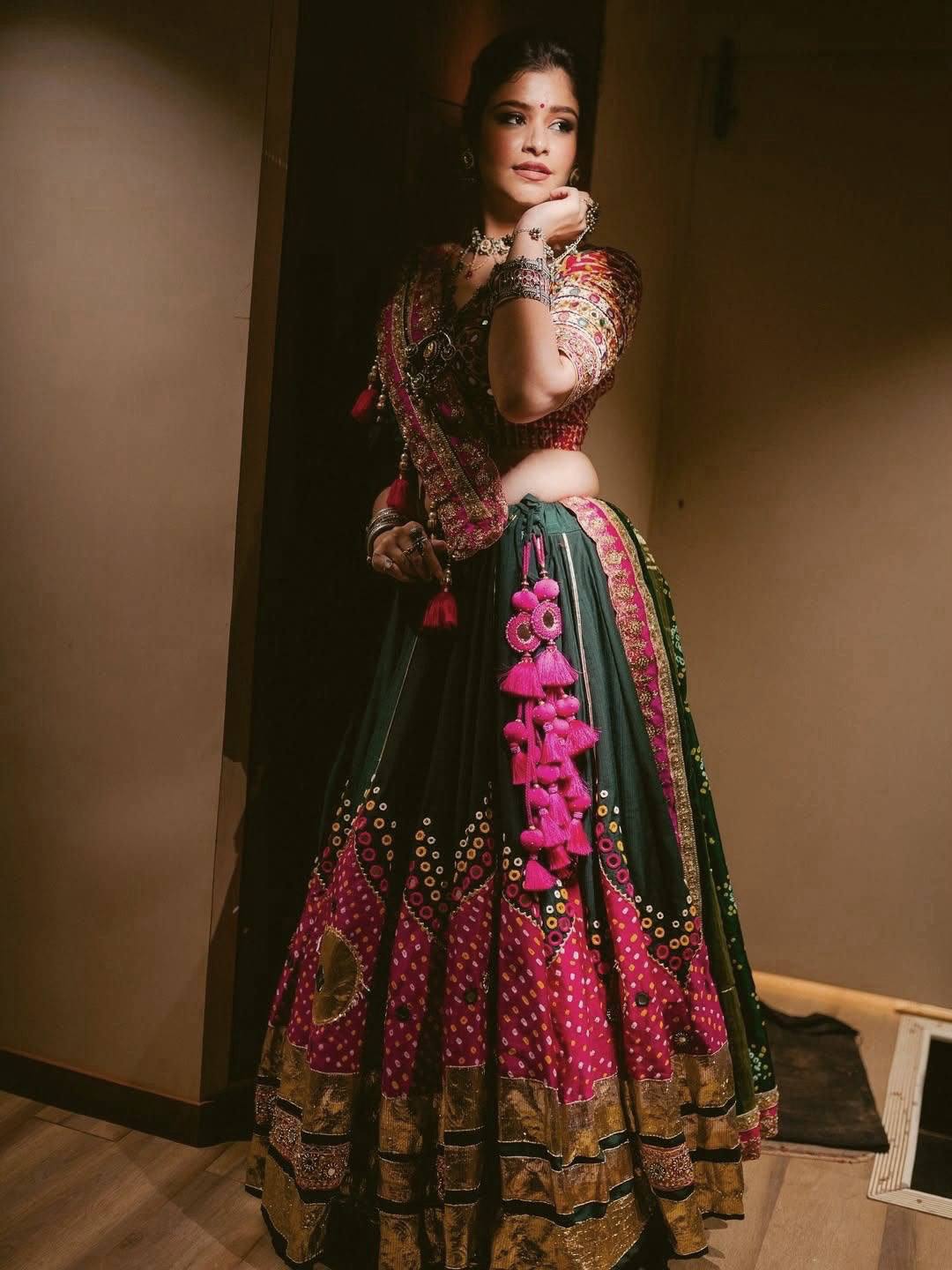 Model posing in Bottle Green & Rani Pink Heavy Muslin Cotton Beautiful Digital Print & Real Mirror Work With Gota Patti Navratri Lehenga Choli Set with Heavy Tassels by The Beauty Queen