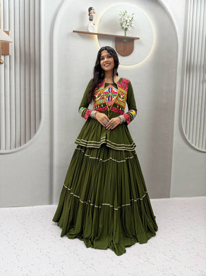 Model Posing Indoors Wearing Dark Olive Green Pure Cotton Heavy Gamthi Work & Mirror Lace With Sikka Lace Navratri Lehenga Choli Set By The Beauty Queen
