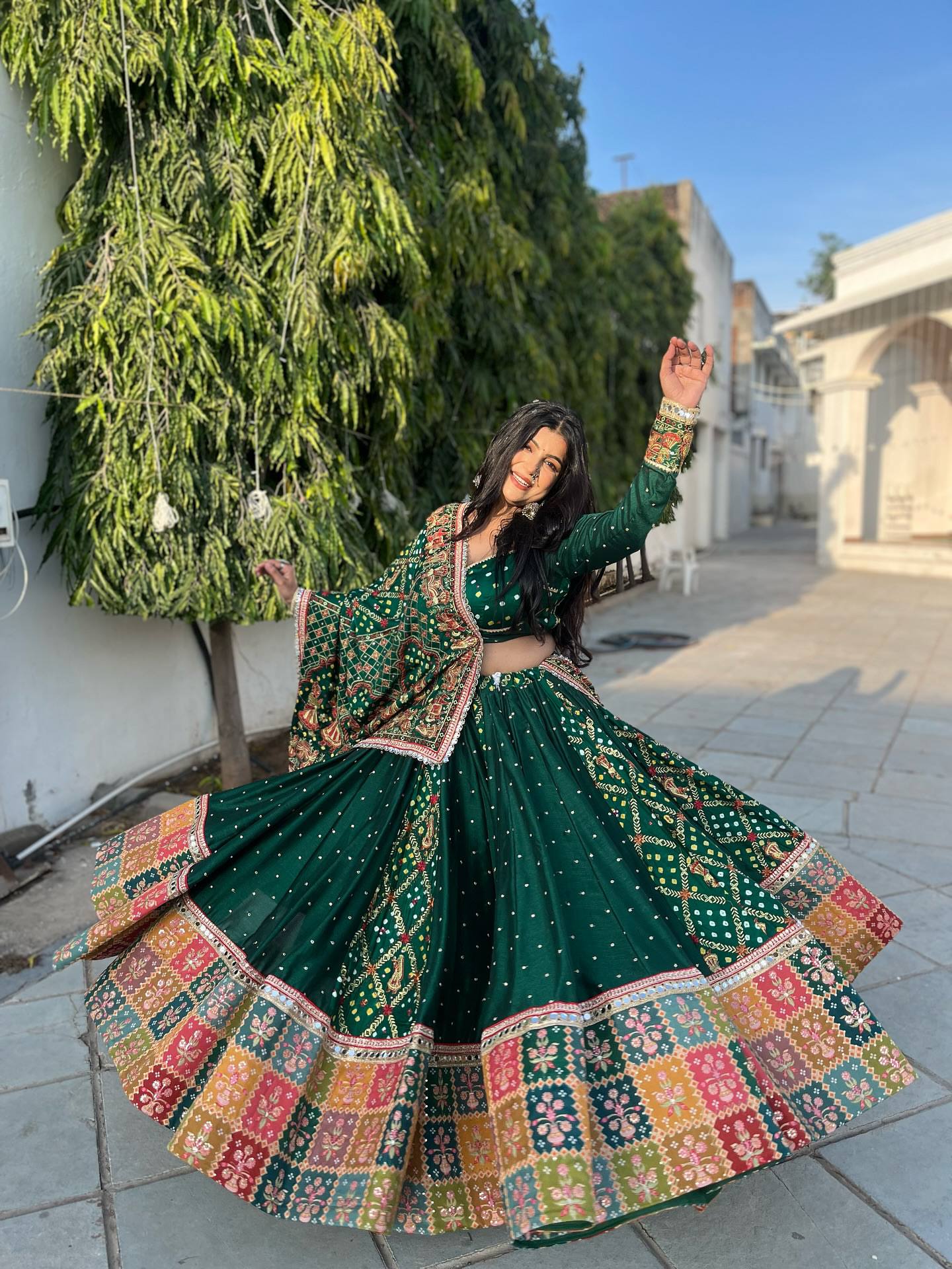 Model twirling in Emerald Green Heavy Muslin Cotton Real Mirror Work Navratri Lehenga Choli Set with Canvas Patta Border by The Beauty Queen