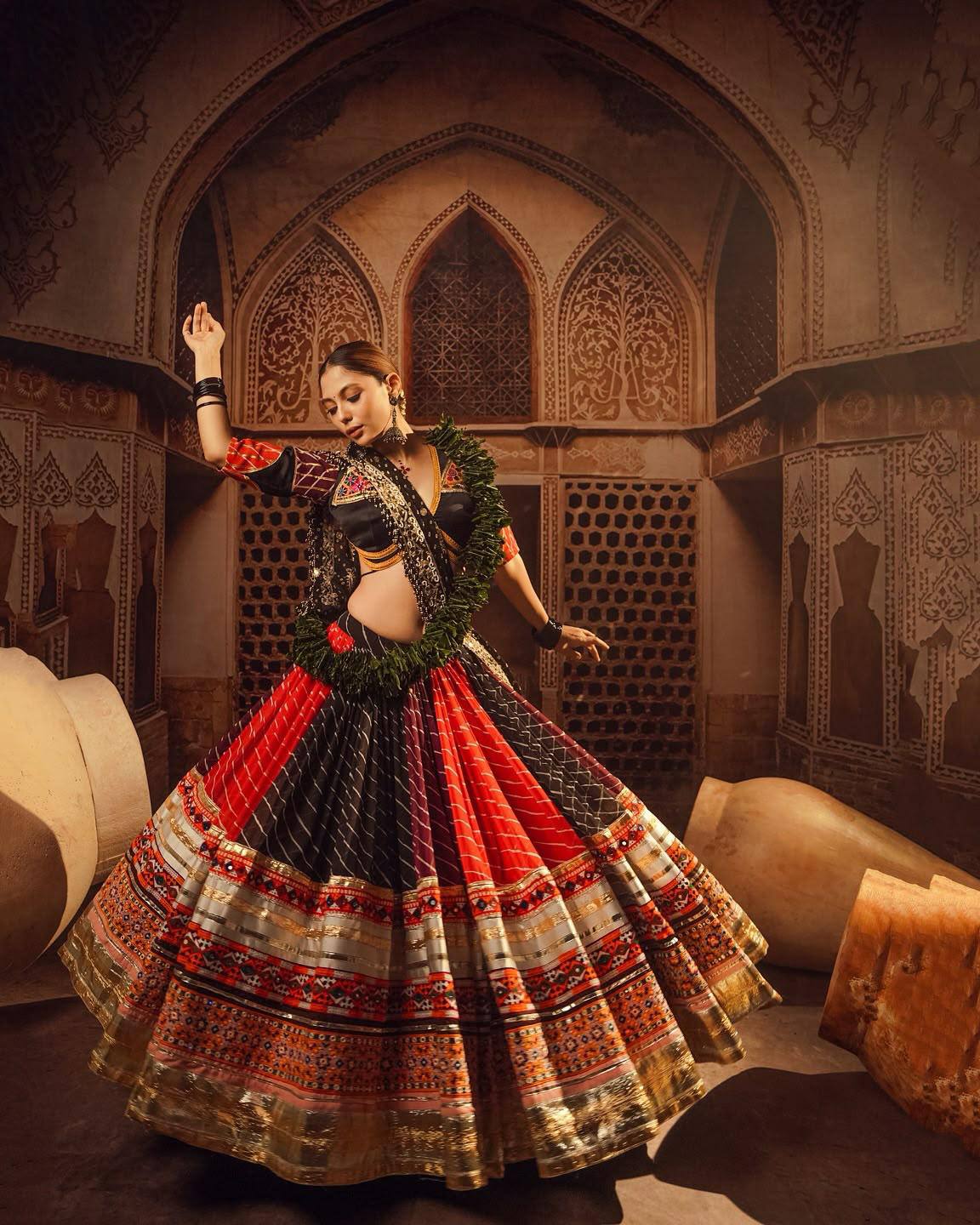 Model Posing In Multi-Color Black & Red Heavy Muslin Cotton With Canvas Patta, Lampi Lace Border & Real Mirror Work Navratri Lehenga Choli Set By The Beauty Queen