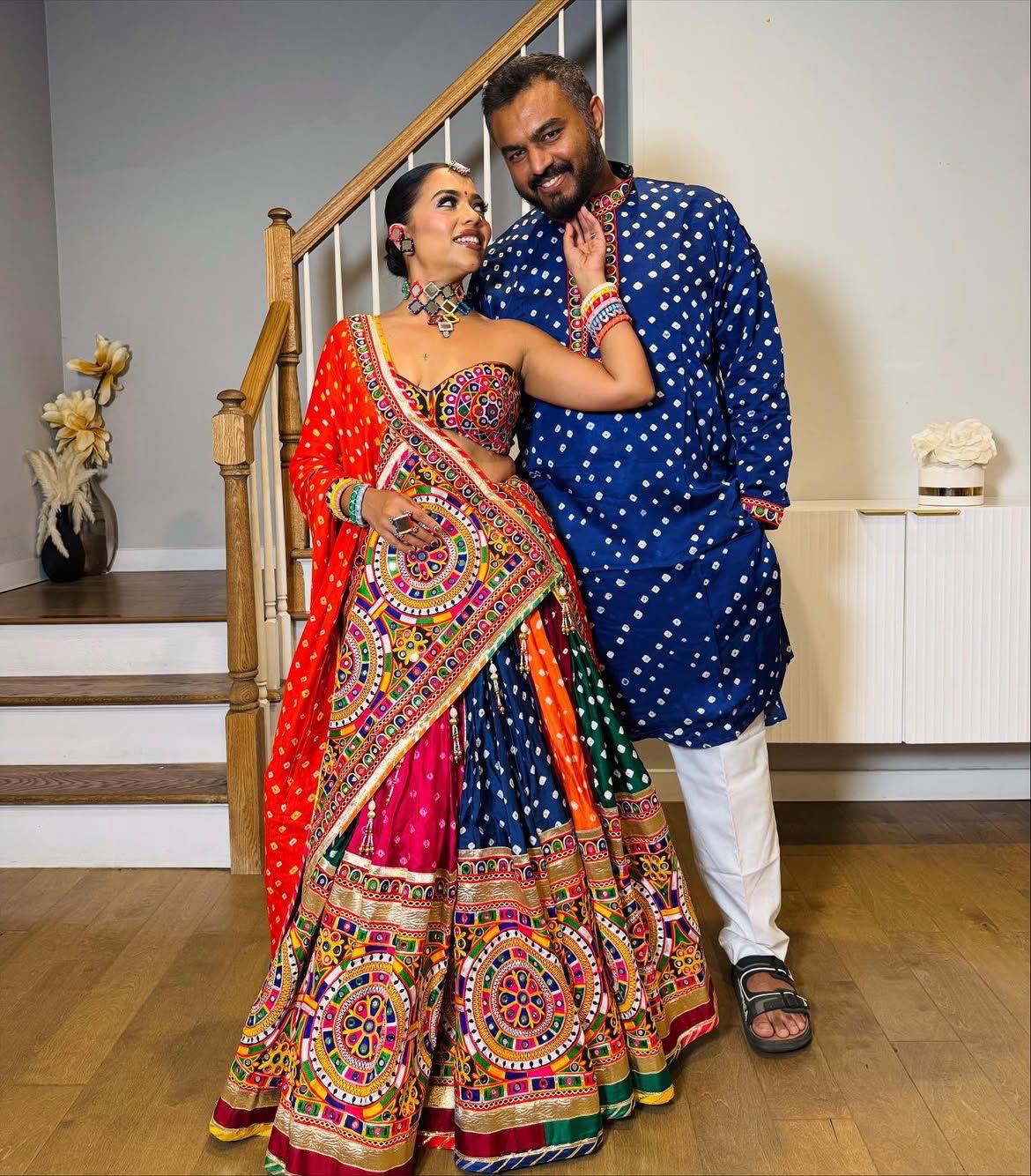 Couple Posing Indoors In Multi-Color Heavy Muslin Cotton Beautiful Digital Print & Real Mirror Work Navratri Lehenga Choli Set By The Beauty Queen