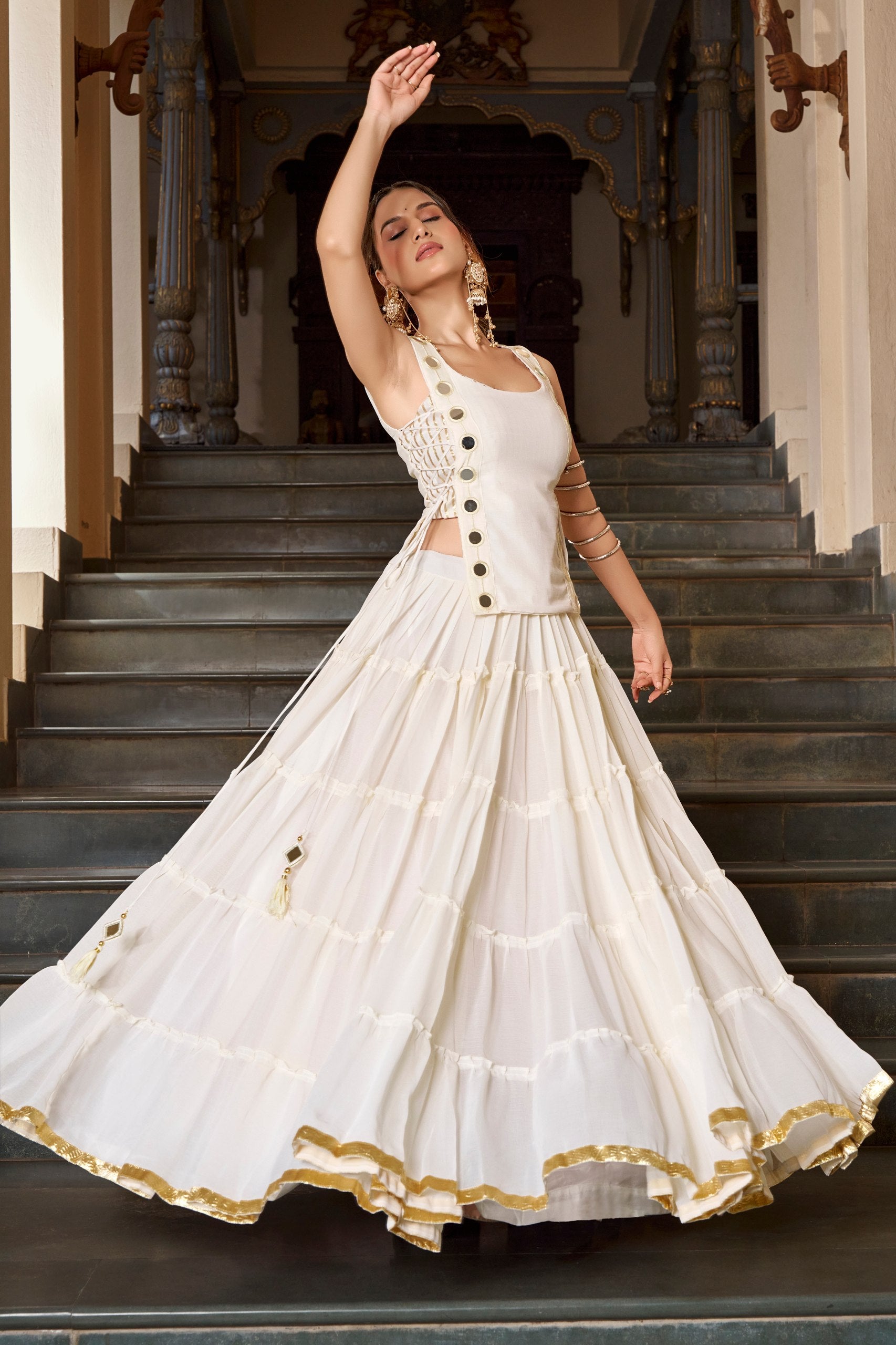 Model Twirling In Off White Lightweight Georgette Tiered Navratri Lehenga Choli Set With Mirror Accents By The Beauty Queen