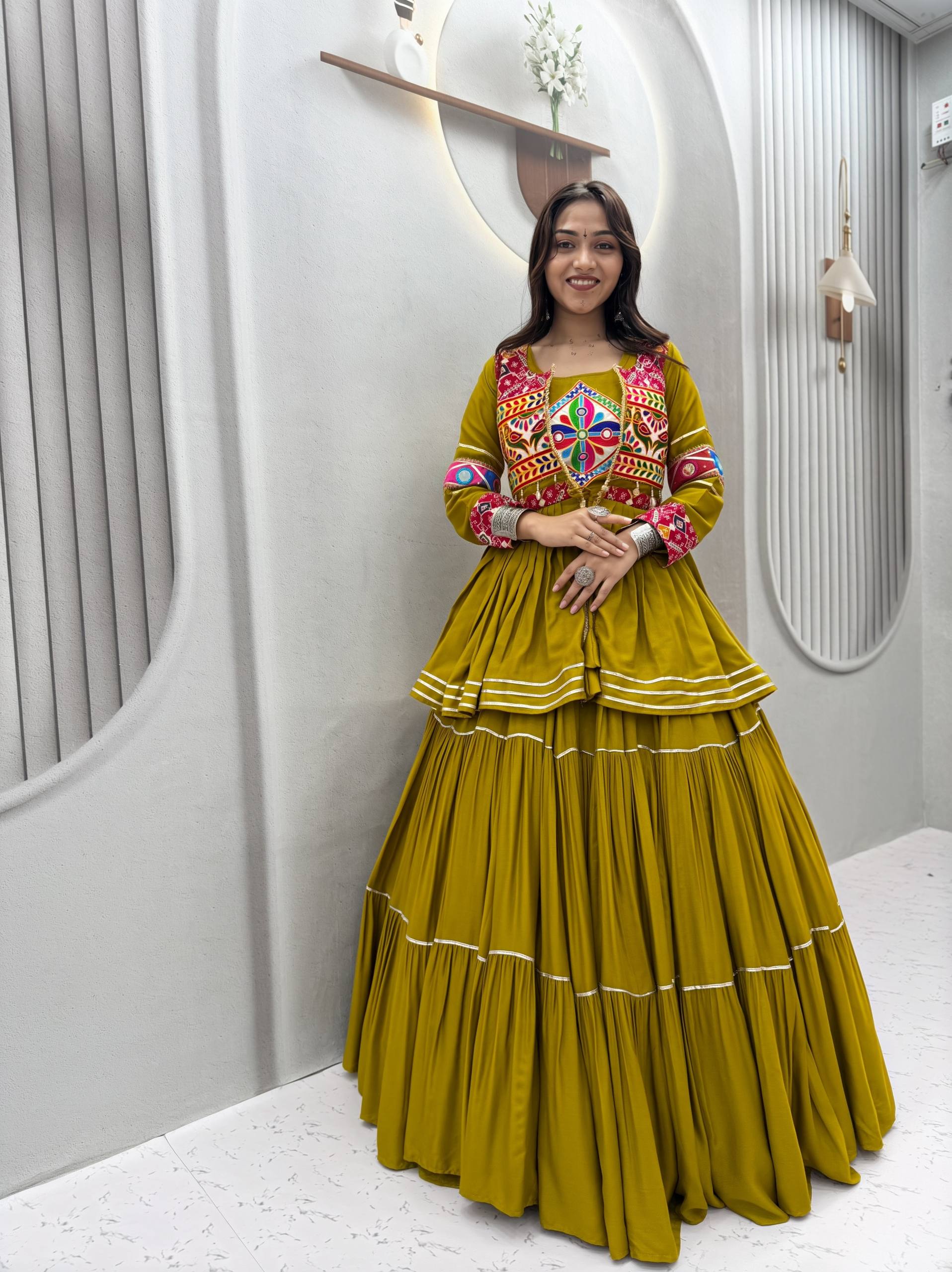 Model Posing Indoors Wearing Olive Green Pure Cotton Heavy Gamthi Work & Mirror Lace With Sikka Lace Navratri Lehenga Choli Set By The Beauty Queen