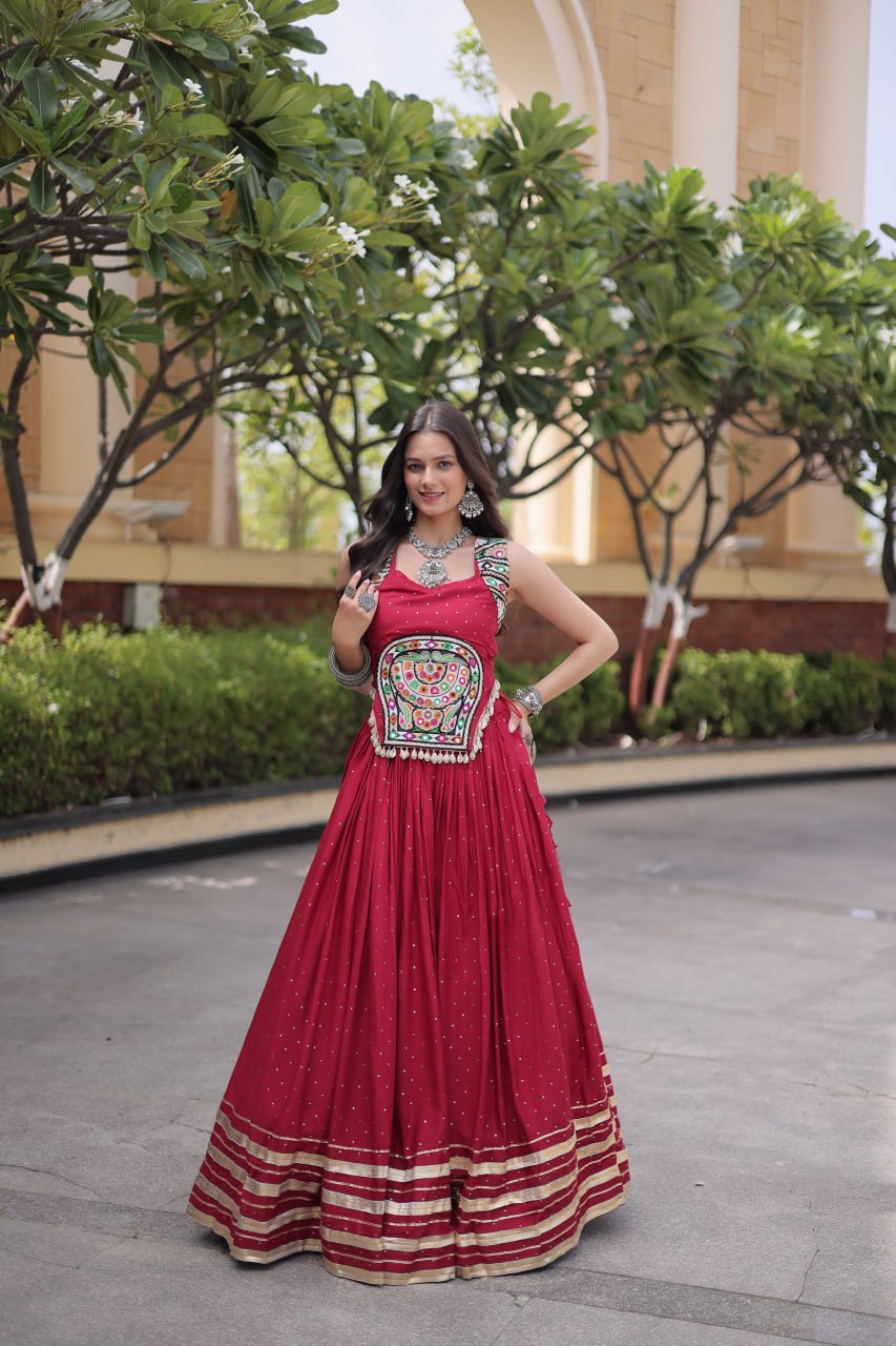 Maroon Crimson Red 14kg Rayon Navratri Special Flared Lehenga Choli Set with Sparkling Mukaish (Badla) Work, Multi-Line Gota Patti Borders & Kutchi Embroidered Cowrie Shell Sleeveless Blouse