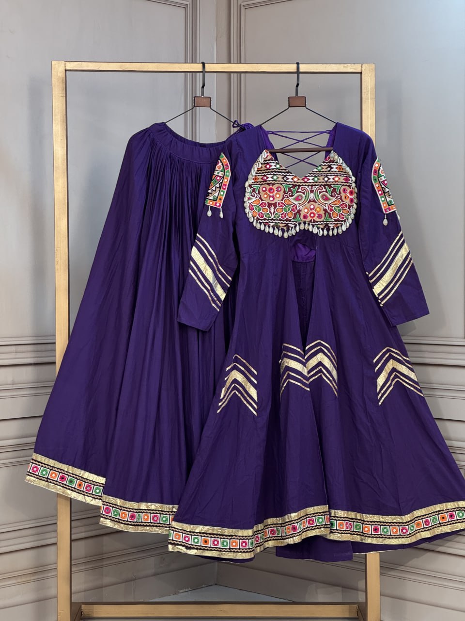 Royal Purple Kora Cotton Navratri Special Flared Lehenga Choli Set with Gujarati Gamthi Embroidery, Cowrie Shell Trims, Chevron Gota Patti & Long Flared Kedia Style Angrakha Top
