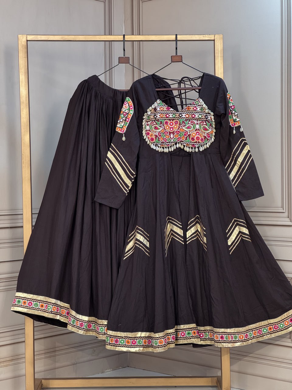 Jet Black Kora Cotton Navratri Special Flared Lehenga Choli Set with Gujarati Gamthi Embroidery, Cowrie Shell Trims, Chevron Gota Patti & Long Flared Kedia Style Angrakha Top