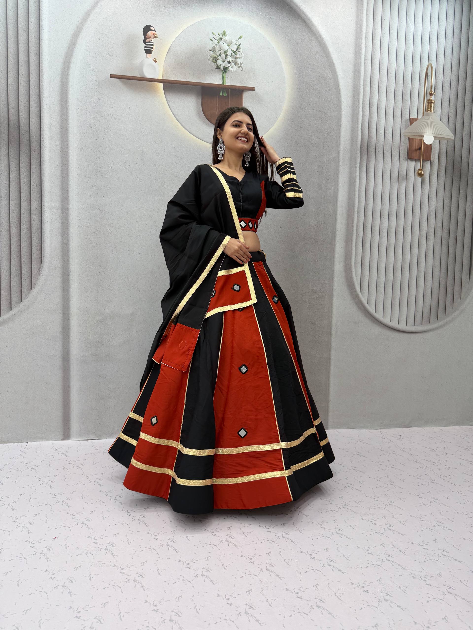 Jet Black & Rust Maroon Color-Blocked Roman Silk Navratri Special Flared Lehenga Choli Set with Real Mirror Work, Gold Gota Patti Borders, Full-Sleeve Blouse & Matching Dupatta