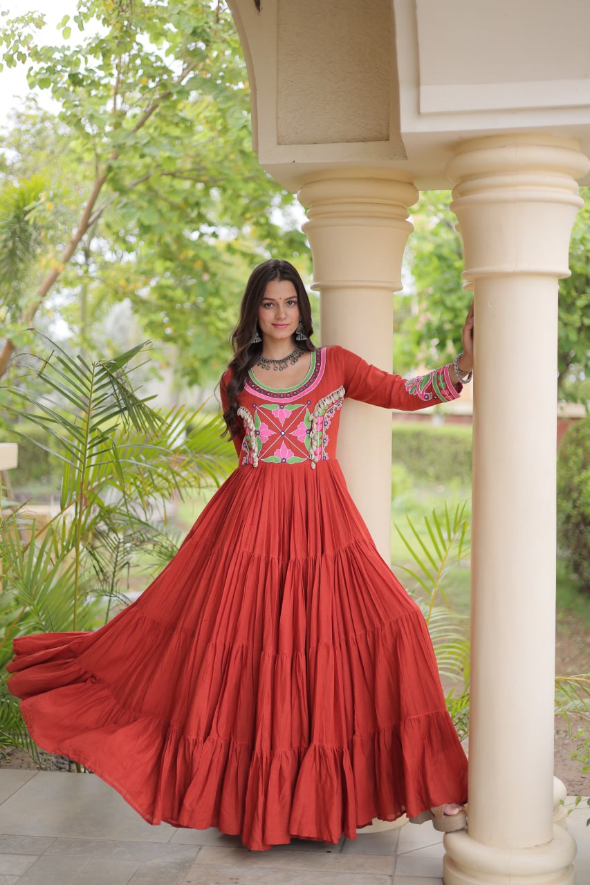 Rust Terracotta Orange Kora Cotton Navratri Special High-Flare Tiered Gown with Multi-Thread Floral Embroidery, Real Mirror Work & Authentic Cowrie Shell (Codi) Embellishments