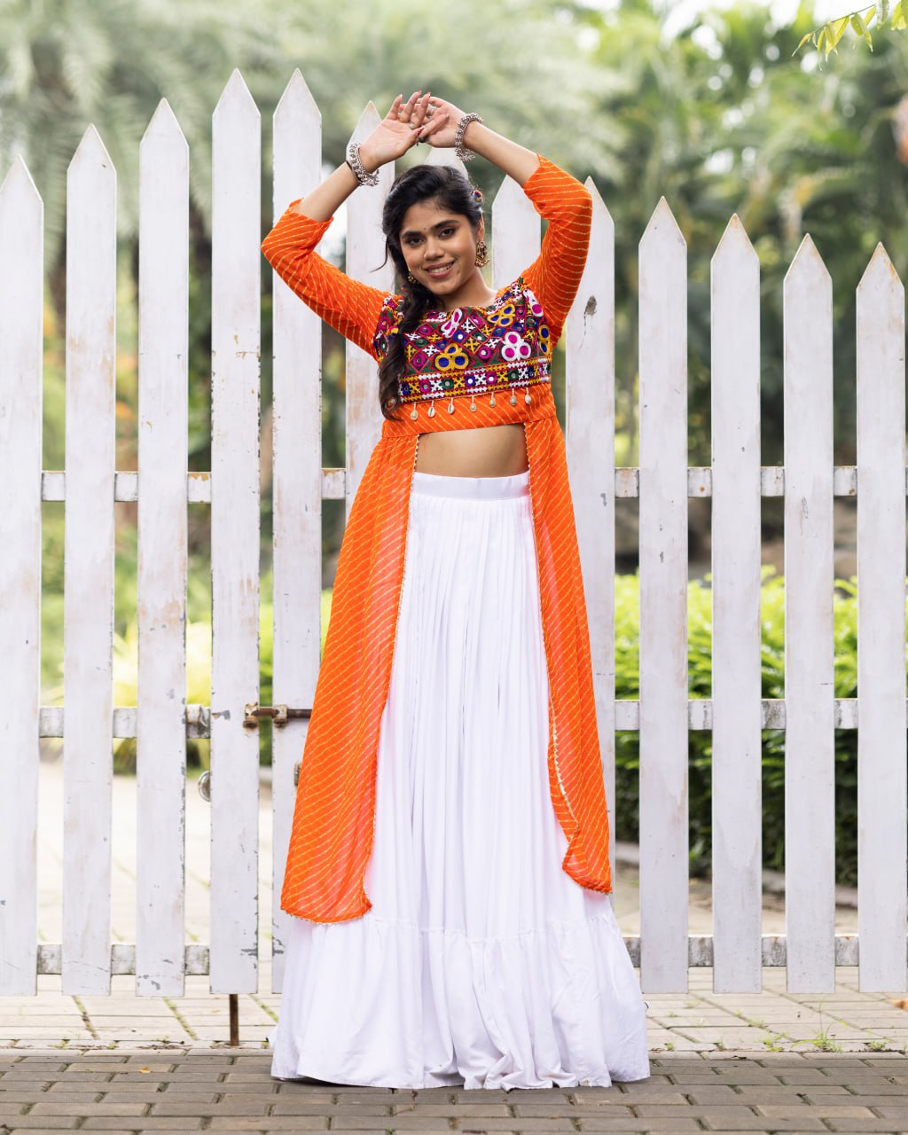White pure rayon cotton plain frill pattern Navratri lehenga with micro cotton inner, orange Kutchi mirror embroidered blouse with cowrie shells, and leheriya long shrug