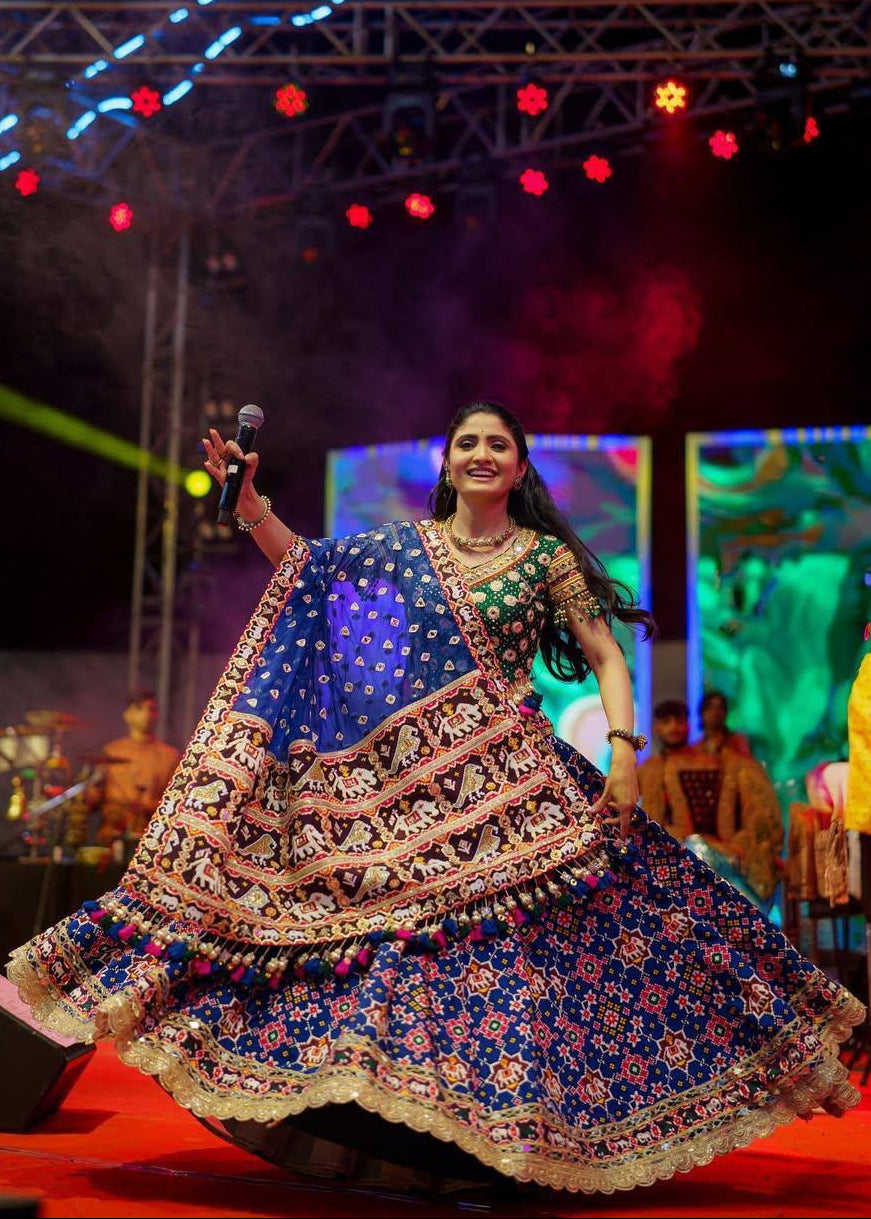Royal blue heavy muslin cotton Navratri lehenga choli with bandhani and elephant patola prints, real mirror work, contrast green blouse, and Reniya cutting border lace