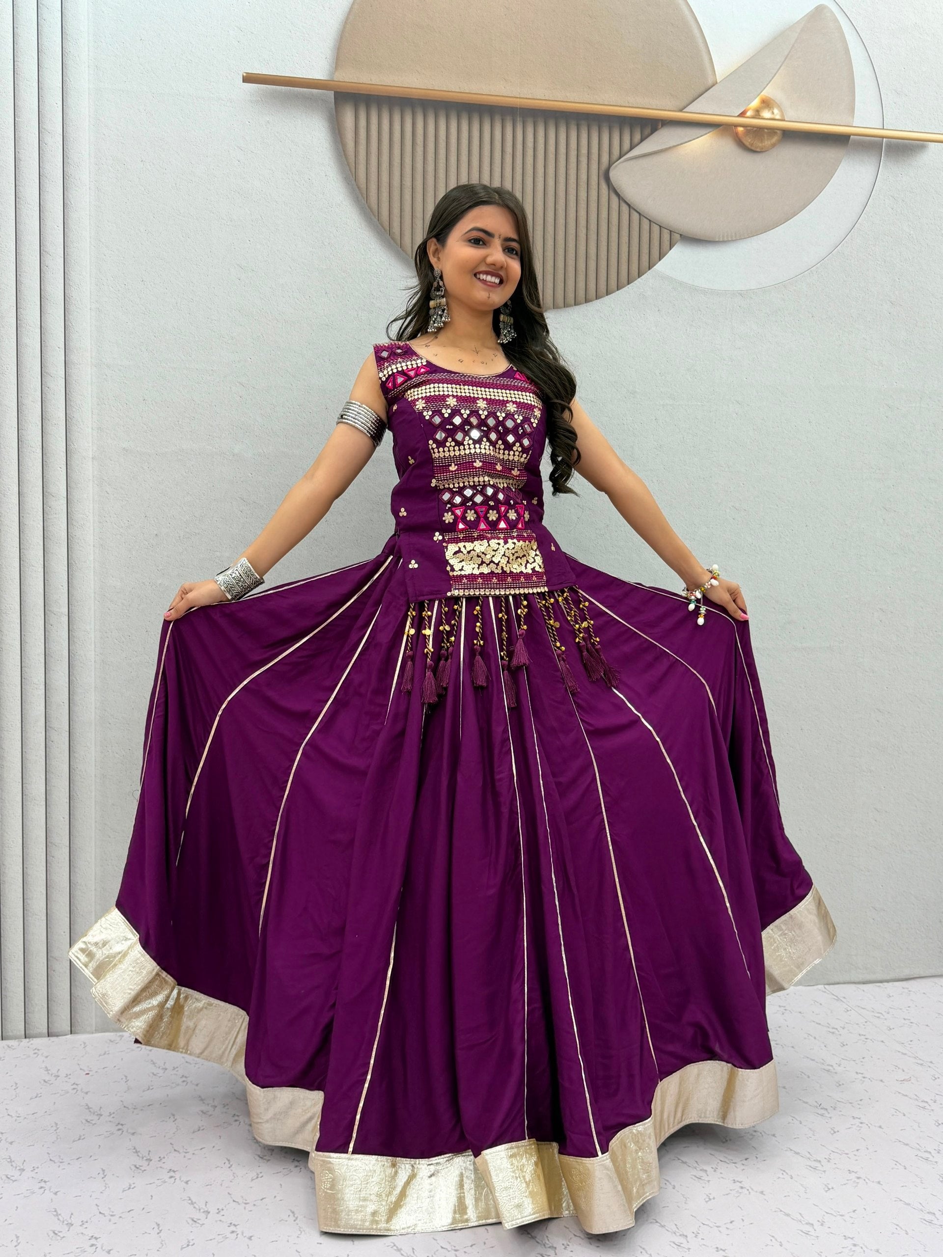 Model Posing Indoors Wearing Purple Pure Cotton Mirror Hand Work & Ribbon Work Navratri Lehenga Choli Set By The Beauty Queen