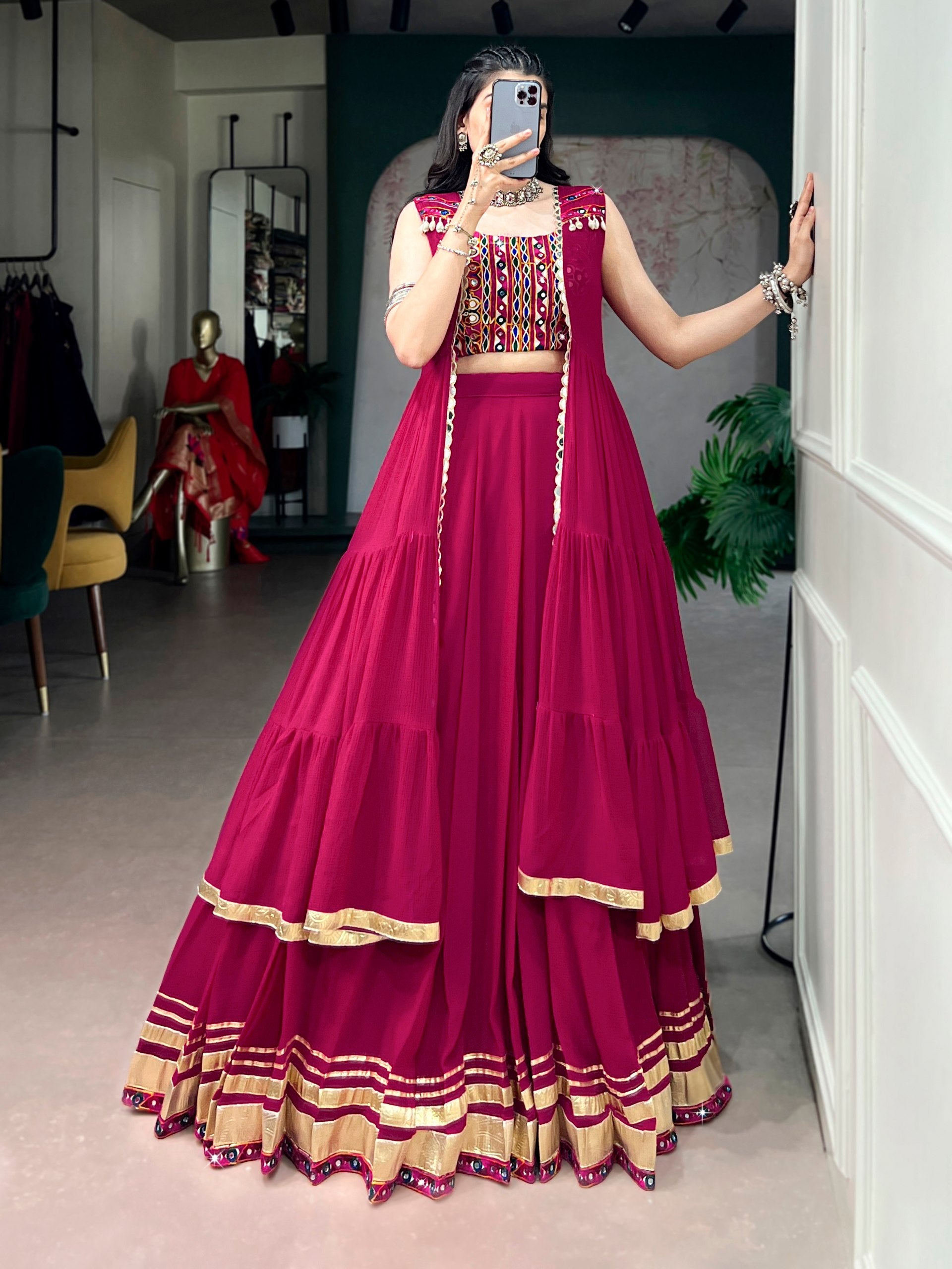 Model wearing Rani Pink Lightweight Lehenga, Gamthi Blouse, Gotta Patti Lace Detailing, And A Mirror-adorned Long Koti Navratri Lehenga Choli Set by The Beauty Queen