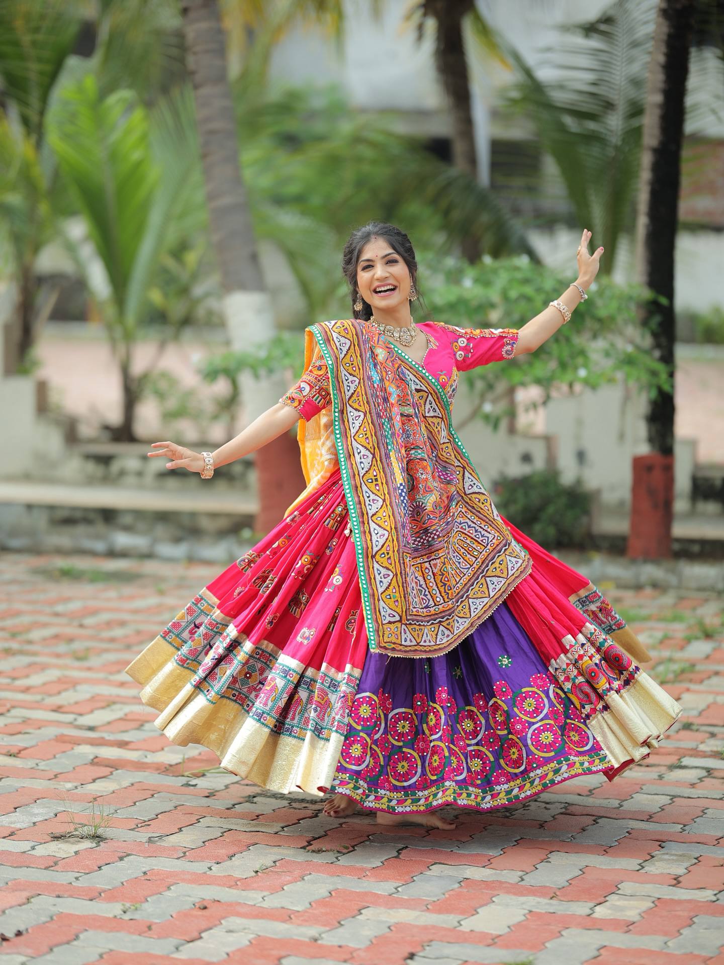 Model Wearing Rani Pink And Purple Heavy Muslin Cotton Gamthi Patchwork And Real Mirror Work Navratri Lehenga Choli Set By The Beauty Queen