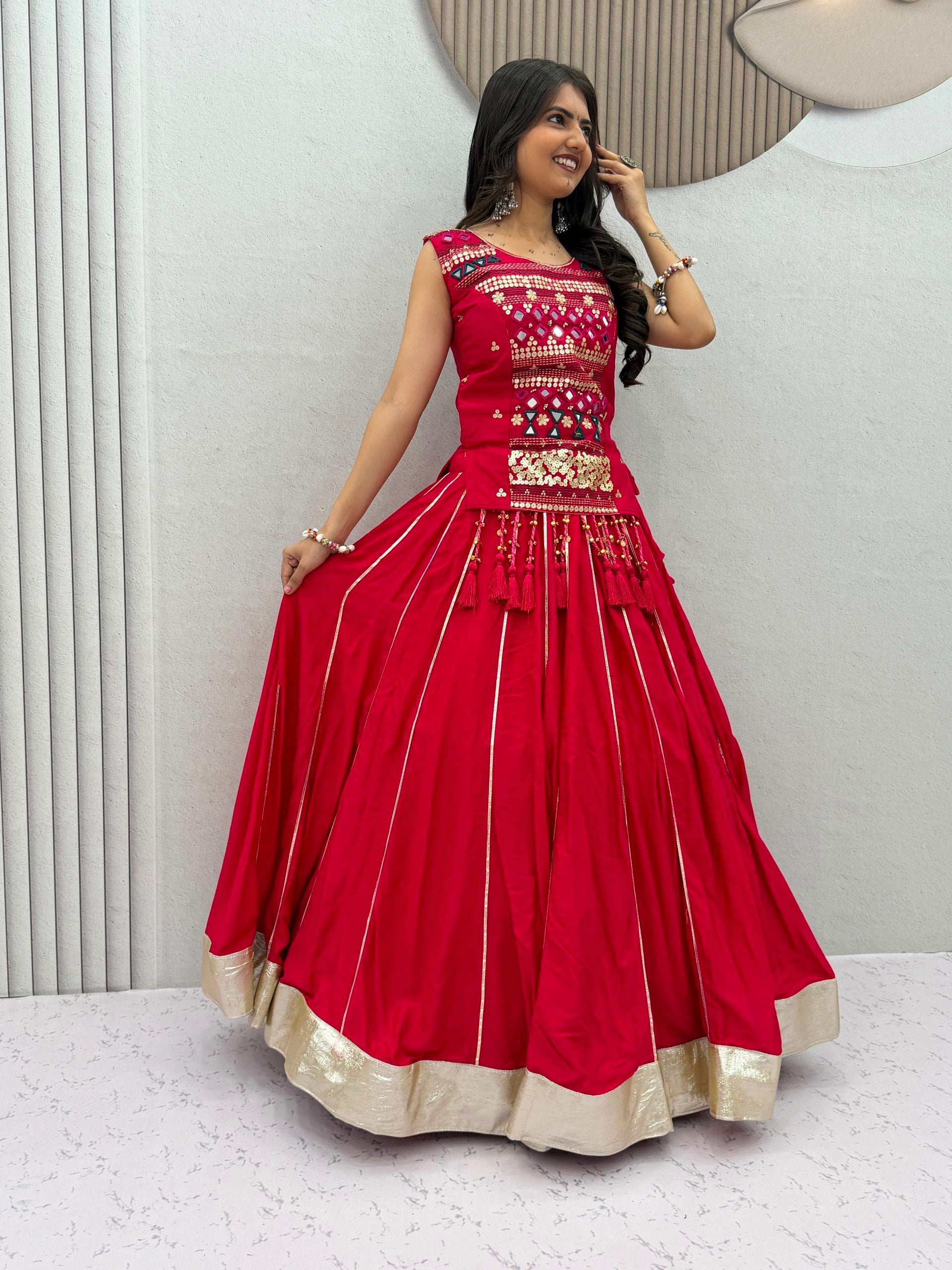 Model Posing Indoors Wearing Red Pure Cotton Mirror Hand Work & Ribbon Work Navratri Lehenga Choli Set By The Beauty Queen