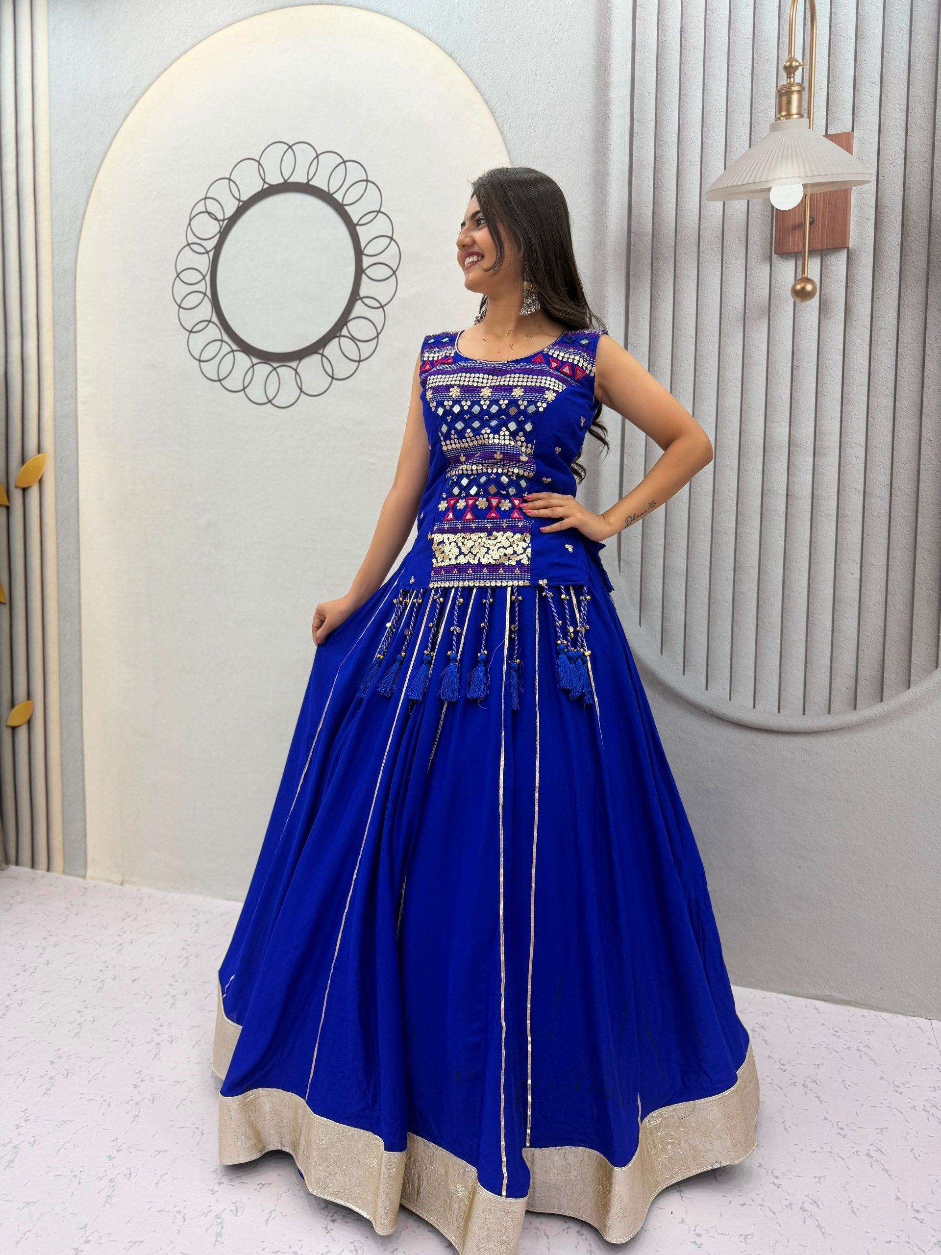Model Posing Indoors Wearing Royal Blue Pure Cotton Mirror Hand Work & Ribbon Work Navratri Lehenga Choli Set By The Beauty Queen