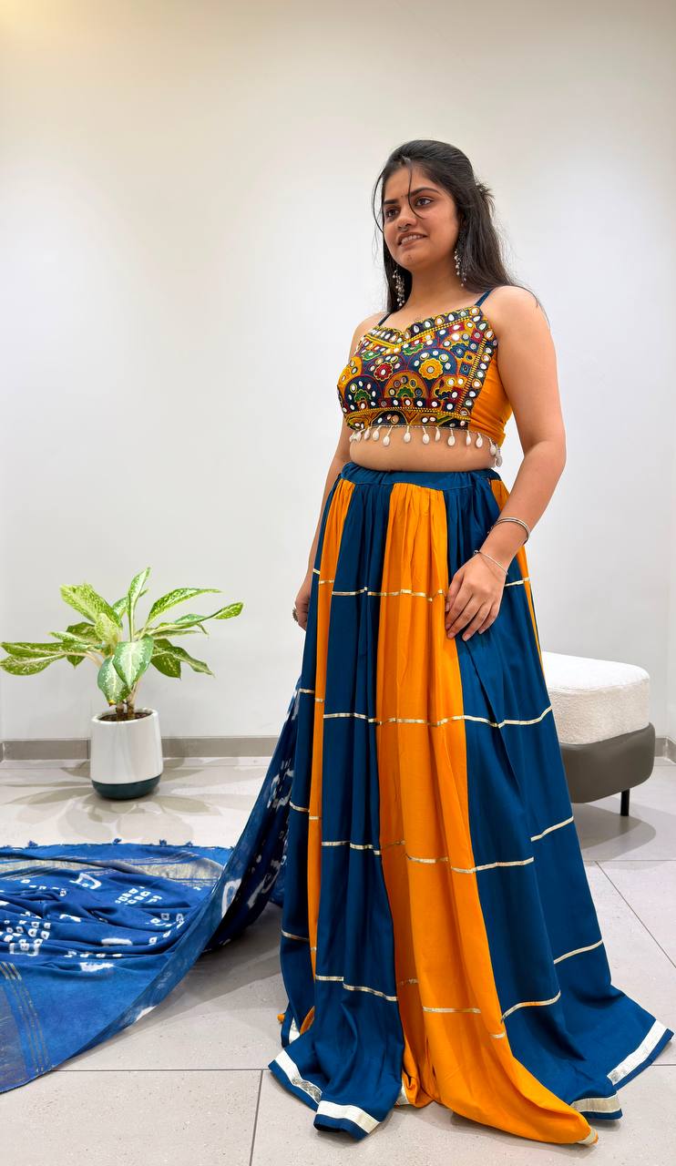 Teal Blue And Yellow Rayon Navratri Lehenga Choli Featuring Real Mirror Work Embroidery And Shell Tassels By The Beauty Queen